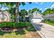 Charming single-story home with a well-manicured lawn, palm trees, and an attached two-car garage at 1231 Wild Olive Dr, Mount Pleasant, SC 29464