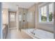 Bright bathroom featuring a glass-enclosed shower, a soaking tub, tile floors, and double vanity sinks at 1363 Rivella Dr, Mount Pleasant, SC 29464