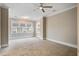 A neutral-toned bedroom with plush carpeting features a ceiling fan and a large window overlooking the yard at 1363 Rivella Dr, Mount Pleasant, SC 29464