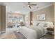 A calming bedroom features a ceiling fan, a seating area, a large window, and a neutral color palette at 1363 Rivella Dr, Mount Pleasant, SC 29464