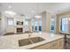Open concept living room with a white fireplace, large windows, and a kitchen island with a sink at 1363 Rivella Dr, Mount Pleasant, SC 29464