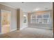 Neutral bedroom featuring plush carpeting, a large window, and a glimpse into the bright ensuite bathroom at 1363 Rivella Dr, Mount Pleasant, SC 29464