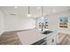 Bright open concept kitchen featuring modern pendant lighting, island sink, and sliding glass doors to outside at 137 Summerwind Dr, Summerville, SC 29486