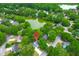 Aerial view of a residential area featuring tree-lined streets, a lake, and houses with well-maintained yards at 1394 Center Lake Dr, Mount Pleasant, SC 29464