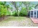 A spacious and shady backyard, featuring a screened porch, patio, and mature trees, providing ample privacy at 1394 Center Lake Dr, Mount Pleasant, SC 29464