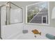 Luxurious bathroom showcasing a soaking tub with a clear glass door shower and backyard view at 1394 Center Lake Dr, Mount Pleasant, SC 29464