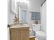 Cozy bathroom with a wooden vanity, decorative seashell, toilet, and a shower behind a white curtain at 1394 Center Lake Dr, Mount Pleasant, SC 29464