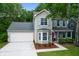 Charming two-story home with light siding, shutters, a garage, and an American flag at 1394 Center Lake Dr, Mount Pleasant, SC 29464