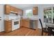 Well-lit kitchen with wooden cabinets, stainless steel dishwasher, and hardwood floors at 1394 Center Lake Dr, Mount Pleasant, SC 29464