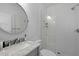 Modern bathroom with a glass shower, marble sink, and a round mirror at 142 President St, Charleston, SC 29403