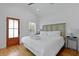 Cozy bedroom with light wood floors, white linens, a decorative headboard, and a modern side table at 142 President St, Charleston, SC 29403