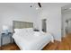 Bright bedroom with hardwood floors, white linens, a decorative headboard, and modern side tables at 142 President St, Charleston, SC 29403