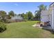 Large grassy backyard with wood fence, patio, outdoor seating, and mature trees providing shade and privacy at 1470 Ashley Gardens Blvd, Charleston, SC 29414