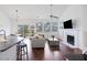 Open-concept living room with fireplace, TV, hardwood floors, and natural light at 1470 Ashley Gardens Blvd, Charleston, SC 29414