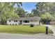 Charming single-story home featuring a landscaped lawn, a welcoming front door with a wreath, and light gray siding at 1515 Mulberry St, Charleston, SC 29407