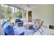 Screened sunroom with neutral rattan furniture and blue cushions offers a view to the backyard at 1515 Mulberry St, Charleston, SC 29407