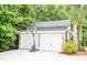 View of a two car garage with a basketball hoop set up in the driveway with palms and greenery at 1566 Lindsey Creek Dr, Mount Pleasant, SC 29466