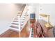 Inviting hallway with hardwood floors, staircase, piano, and sophisticated furnishings at 1566 Lindsey Creek Dr, Mount Pleasant, SC 29466
