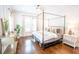 Bright main bedroom featuring a canopy bed, hardwood floors, and modern decor at 1566 Lindsey Creek Dr, Mount Pleasant, SC 29466