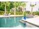 A luxurious pool area with dining, mature palms, lounge chairs and fire bowls provides an outdoor oasis at 1566 Lindsey Creek Dr, Mount Pleasant, SC 29466
