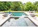 View of a large pool with a connected spa, stylish patio furniture, manicured lawn, and mature landscaping at 1566 Lindsey Creek Dr, Mount Pleasant, SC 29466