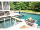 View of a luxurious pool area with a spa, fire bowls, and stylish patio furniture under string lights at 1566 Lindsey Creek Dr, Mount Pleasant, SC 29466