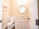 Elegant powder room featuring a marble countertop, white vanity, and stylish octagonal mirror at 1566 Lindsey Creek Dr, Mount Pleasant, SC 29466