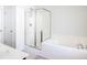 Bright bathroom features a shower with glass door, white tile, and large soaking tub at 1749 Towne St, Johns Island, SC 29455