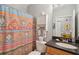 Cozy bathroom features a toilet, a sink with granite countertops and colorful shower curtain at 1984 Folly Rd # A310, Charleston, SC 29412