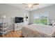 Bedroom featuring wood floors, a ceiling fan, and a large window with a green outdoor view at 1984 Folly Rd # A310, Charleston, SC 29412
