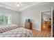 Bright bedroom featuring two beds, wood floors, a dresser, and natural light from the window at 1984 Folly Rd # A310, Charleston, SC 29412