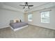 Spacious bedroom with plush carpet, ceiling fan, tray ceiling, and natural light at 201 Bigleaf Ct, Summerville, SC 29486