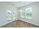Bright breakfast nook featuring wood floors, large windows with backyard view, and a modern chandelier at 201 Bigleaf Ct, Summerville, SC 29486