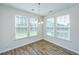 Bright breakfast nook with wood floors, three large windows, and a modern chandelier at 201 Bigleaf Ct, Summerville, SC 29486