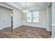 Formal dining room featuring wood floors, wainscoting, large windows, and a modern chandelier at 201 Bigleaf Ct, Summerville, SC 29486