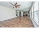Spacious living room with hardwood floors, fan and kitchen area in the background at 201 Bigleaf Ct, Summerville, SC 29486