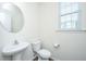 Tastefully designed powder room featuring round mirror and wood-look floors at 201 Bigleaf Ct, Summerville, SC 29486