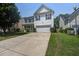 Classic white two-story home with blue shutters, an attached garage, and a concrete driveway at 2021 Asher Loop, Summerville, SC 29485