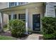 Inviting front porch with decorative shrubs and a charming front door with glass at 2021 Asher Loop, Summerville, SC 29485