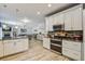 Open kitchen features white cabinetry, stainless steel appliances, granite counters and hardwood floors at 2021 Asher Loop, Summerville, SC 29485