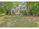 Two-story home with neutral siding, black shutters, and mature trees and landscaping at 2028 Prospect Hill Dr, Mount Pleasant, SC 29464