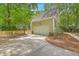 Attached two-car garage with concrete driveway surrounded by mature landscaping and a picket fence at 2028 Prospect Hill Dr, Mount Pleasant, SC 29464