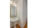 Powder room with pedestal sink, gold mirror and hardwood floors at 2028 Prospect Hill Dr, Mount Pleasant, SC 29464