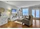 Comfortable living room featuring hardwood floors, a cozy chair, and large windows with ample natural light at 2064 Promenade Ct, Mount Pleasant, SC 29466