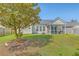 Home features a spacious backyard with green grass and an inviting screened-in porch at 210 Delafield Dr, Summerville, SC 29483