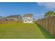 Large grassy backyard featuring a full fence and view of the home's rear exterior at 211 Saxony Loop, Summerville, SC 29486