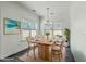 Dining room features wood table, six chairs, and bright sunlight near a piece of beach artwork at 211 Saxony Loop, Summerville, SC 29486