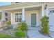 Inviting front porch with stone accents, manicured landscaping, and decorative plants at 211 Saxony Loop, Summerville, SC 29486