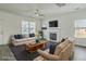 Bright living room with fireplace, ceiling fan, grey wood floors, neutral furniture and lots of natural light at 211 Saxony Loop, Summerville, SC 29486