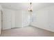 Neutral bedroom with a chandelier, white walls and trim, and a double-door closet at 2267 N Marsh Dr, Mount Pleasant, SC 29466